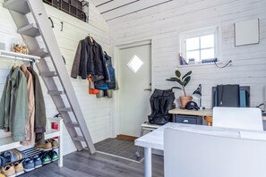 A modern, well-lit room with a staircase, a desk with a computer, a potted plant, and a window. - The Aspö Island Hideaway, Drottningskär, Sweden (Drottningskär)