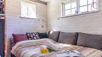 A bedroom with a bed, pillows, a window, and a book.