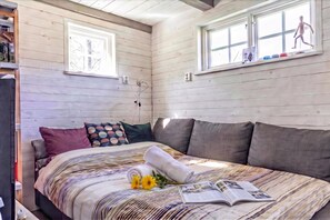 A bedroom with a bed, pillows, a window, and a book. - The Aspö Island Hideaway, Drottningskär, Sweden (Drottningskär)
