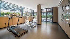 A gym with treadmills, stationary bikes, and a rowing machine. - Baihe yiting jiudian (Foshan)