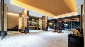 A modern lobby with a wooden ceiling, a reception desk, and a seating area. - Baihe yiting jiudian (Foshan)