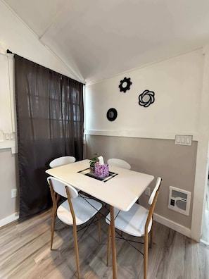 Un comedor con una mesa, sillas y una pared decorada con detalles metálicos.