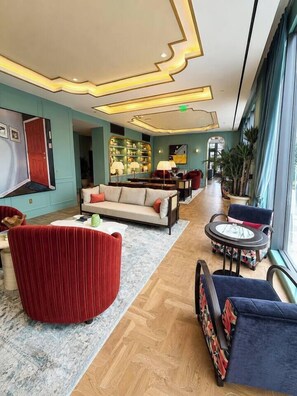 A hotel lobby with a sofa, chairs, a coffee table, and a staircase.