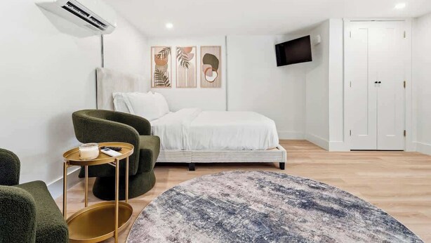 A bedroom with a bed, a television, a wardrobe, and a small table with a candle.