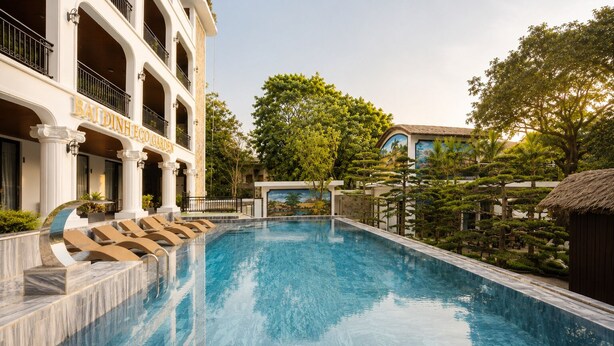Una piscina con un edificio en el fondo que dice 'BAIDINH ECO GARDEN'.