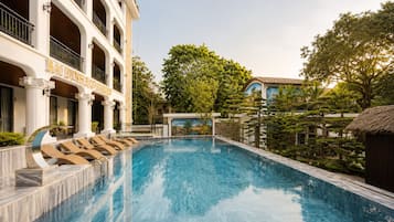 A swimming pool with a building labeled 'BAIDINH ECO GARDEN' in the background.