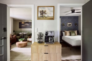 A room with a bed, a coffee maker, a wooden chest of drawers, and a painting on the wall. - Private Retreat:: Hot Tub, Sauna & Fire Pit (Logan)
