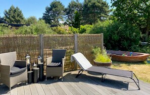 A deck with outdoor furniture, a small boat, and a wooden fence. - 4 bedroom awesome home in Sjællands Odde (Sjællands Odde)