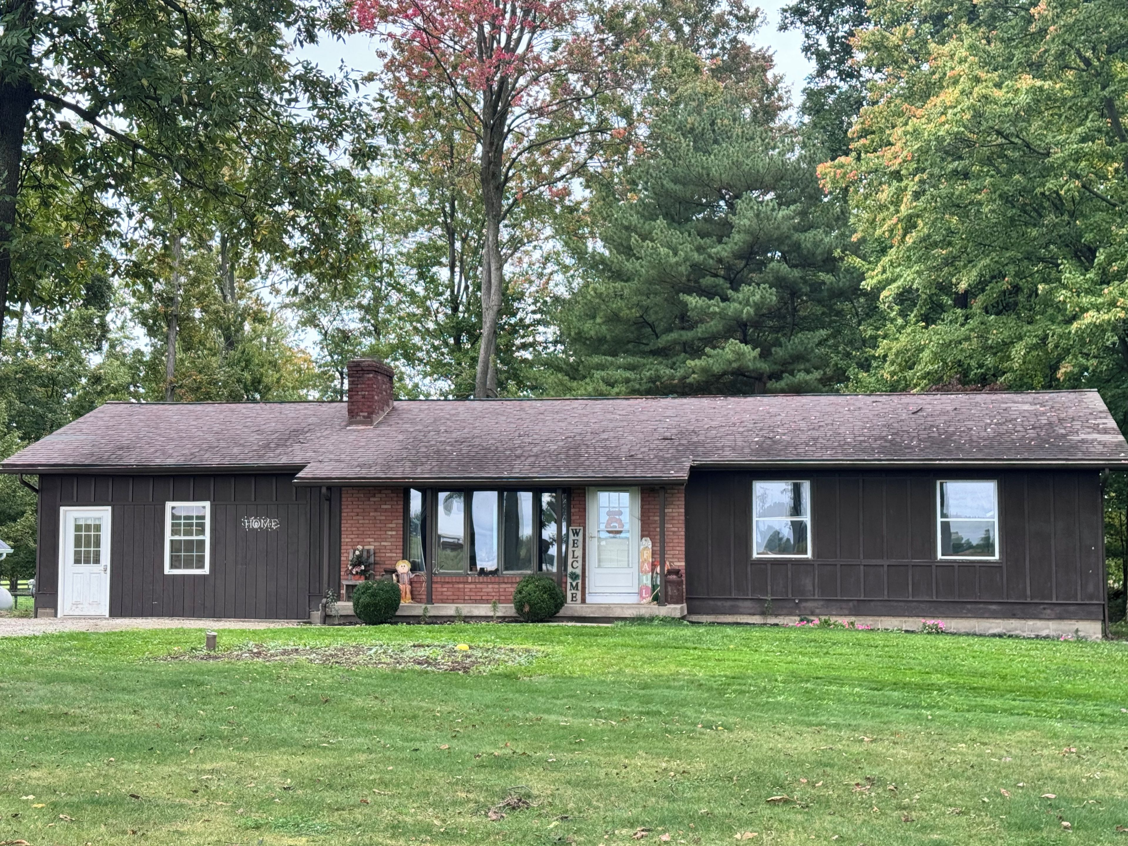A two-story building with a brick facade, a front porch, and a well-maintained lawn.