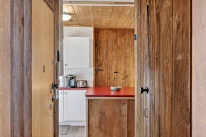 A kitchen with wooden cabinets, a red countertop, and white appliances. - NEW! City Explorer Basecamp Buffalo (Buffalo)