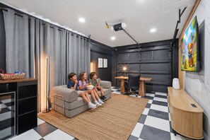 Ein Wohnzimmer mit einer Couch, einem Tisch und einem Fernseher.