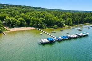 A lakeside property with a dock, boats, and a beach area. - Family Getaway at Shanty Creek | Pools, Skiing & Lake Views (Bellaire)