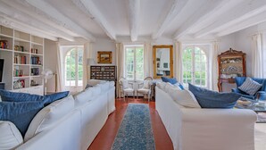 A room with white sofas, a blue rug, and a bookshelf. - Le Mas de Villecroze - Belle piscine extérieure (Villecroze)