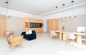A modern reception area with a desk, chairs, and a TV screen. - Stunning home in Lanzarote with private swimming pool, can be inside or outside (Lanzarote)