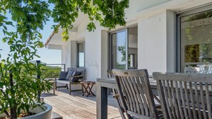 A wooden deck with outdoor furniture, a potted plant, and a view of the sky. - La Vigie - Ville d'Hiver (Arcachon)
