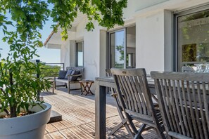 A wooden deck with outdoor furniture, a potted plant, and a view of the sky. - La Vigie - Ville d'Hiver (Arcachon)