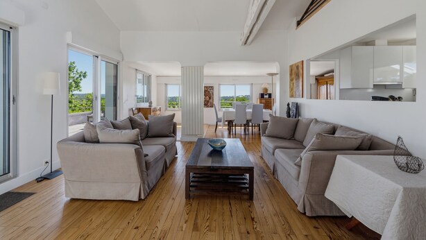 A spacious living area with a wooden floor, two sofas, a coffee table, and a dining area with chairs and a table. - La Vigie - Ville d'Hiver (Arcachon)
