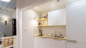 A compact kitchen with white cabinets, a wooden countertop, and a tiled backsplash. - L’Escapade Bourguignonne - Centre-ville de Dijon (Dijon)