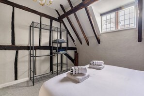 A room with a bunk bed, a metal shelf unit, and a window with a view.