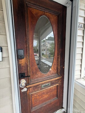 A wooden front door with a large oval mirror, a mailbox, and a doorbell. - 5AC Driveway
4BR
Tufts ~ Downtown Boston (Somerville)