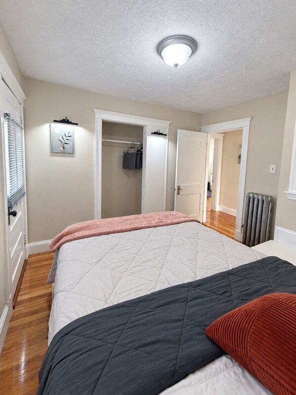 Une chambre à coucher avec un lit, une armoire et un couloir menant à une autre pièce.
