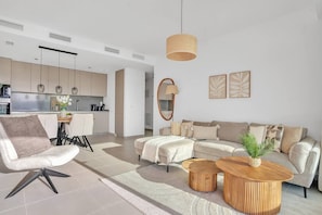 Ein modernes Wohnzimmer mit einer Couch, einem Couchtisch und einem Essbereich mit Stühlen und Tisch.