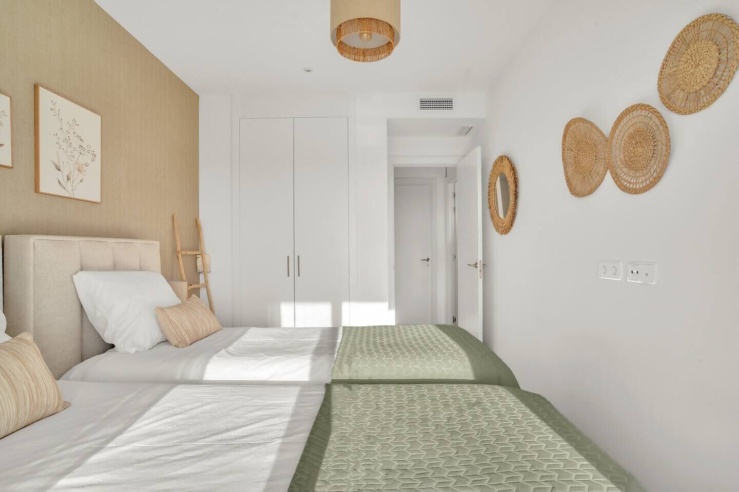 Une chambre à coucher comprenant un lit, une armoire, un miroir et un luminaire suspendu.