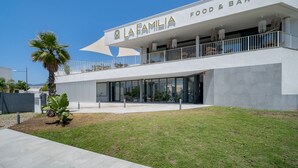 Een modern gebouw met een bord waarop 'LA FAMILIA FOOD & BAR' staat.