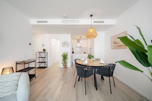 A modern interior with a dining area, a kitchen, and a living space. - Ampartment Ocena Views (Atalaya Isdabe)