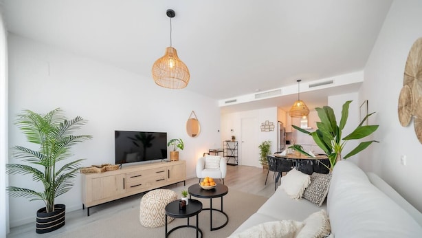 Ett modernt vardagsrum med en soffa, en tv och en matplats.
