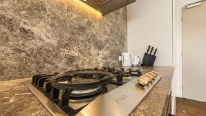 Eine Küche mit Gaskochfeld, Kaffeemaschine und einem Messerblock.