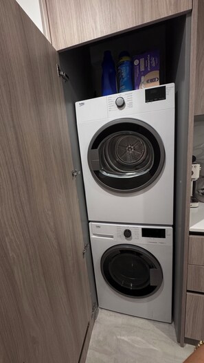 Lavadora compacta de dos puertas con panel de control en la puerta superior.
