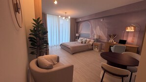 Una camera d'hotel moderna con un letto, un'area salotto e una scrivania.