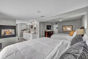 A hotel room with a large bed, a TV, a bathroom with a mirror, and a desk. - Family-Friendly 4BR Home Close to Las Vegas Strip & Airport with Game Room! (Las Vegas)