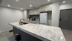 Eine moderne Küche mit Marmorarbeitsplatte, integrierten Geräten und einem eleganten Design.