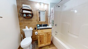 Un bagno dotato di WC, lavabo, mobile vanitario, specchio e doccia.