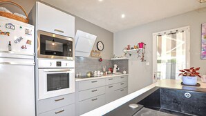 Una cucina moderna con frigorifero, forno a microonde, forno e macchina del caffè.