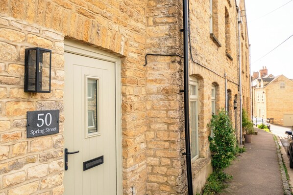A stone building with a door labeled '50 Spring Street.' - Beautiful Townhouse in the Cotswolds (Chipping Norton)
