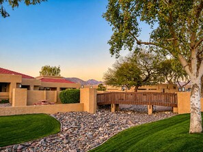 A courtyard with a stone pathway, a wooden fence, and a tree. - Pet-Friendly 2BR | Fenced Yard | 2 Community Pools (Scottsdale)