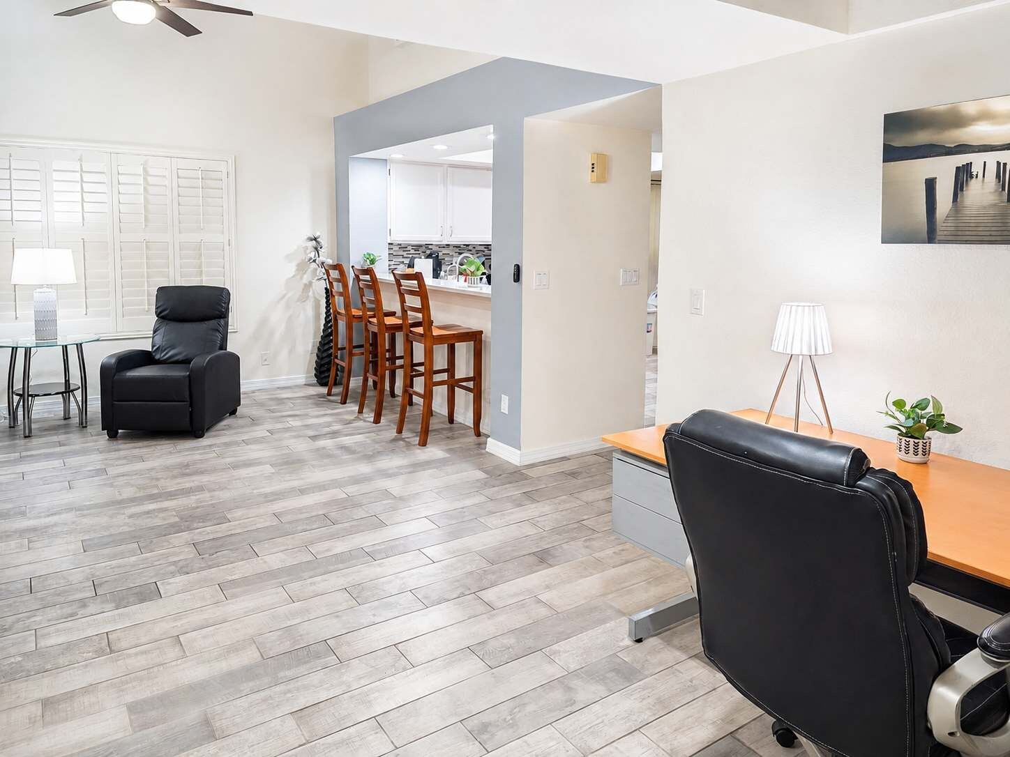 A modern interior with a dining area, a kitchen, and a desk with a chair.