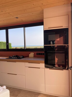 A kitchen with a view of the sea, a Bosch oven, and a gas stove. - La Grange d'Ella in the Cotentin Peninsula, ocean view, beach 1 km away, near Barfleur (Vicq-sur-Mer)