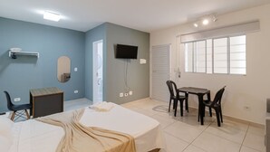 A bedroom with a bed, a desk, a chair, a TV, and a window. - Studio 07 com Wi-fi e Pr Ximo ao Shopping Tatuap (São Paulo)