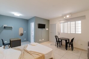 A bedroom with a bed, a desk, a chair, a TV, and a window. - Studio 07 com Wi-fi e Pr Ximo ao Shopping Tatuap (São Paulo)