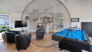 A modern living room with a pool table, comfortable seating, a flat-screen TV, and a dining area. - Gorgeous home in Rødby with sauna (Rødby)
