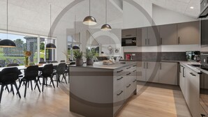 A modern kitchen with a central island, pendant lighting, and a view of greenery outside. - Gorgeous home in Rødby with sauna (Rødby)