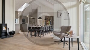 A modern interior with a dining area, kitchen, and a fireplace. - Gorgeous home in Rødby with sauna (Rødby)