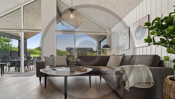 A modern living room with a sofa, coffee table, and dining area. - Gorgeous home in Rødby with sauna (Rødby)