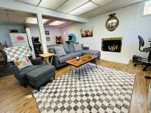 A living room with a sofa, armchair, coffee table, and a fireplace.