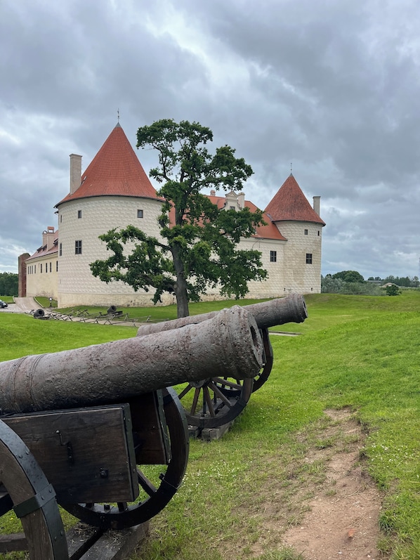 A historic building with a large cannon in the foreground.
