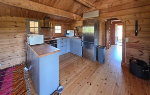 A wooden cabin interior with a kitchen featuring a refrigerator, oven, and sink. - Nice home in Tuddal with house a mountain view (Tuddal)
